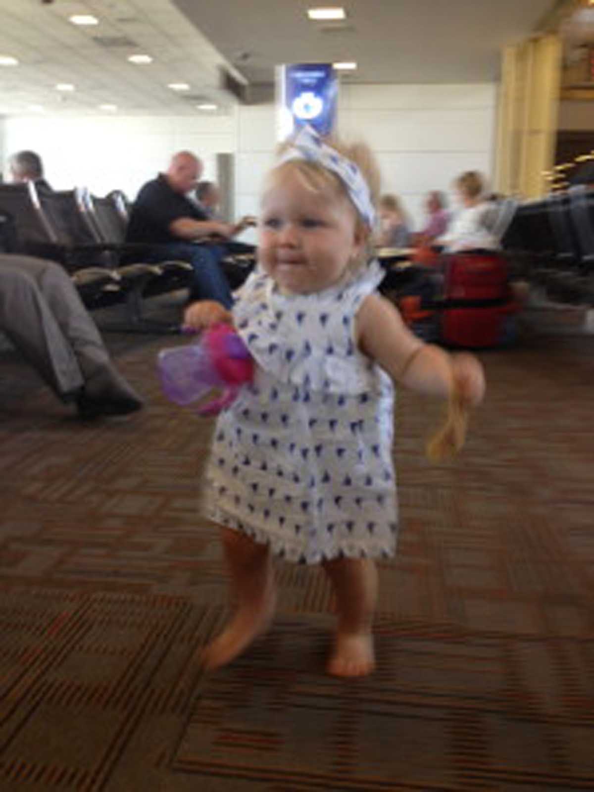 At the airport waiting for our flight. Again our girl all smiles running around the airport.. with pizza of course. 