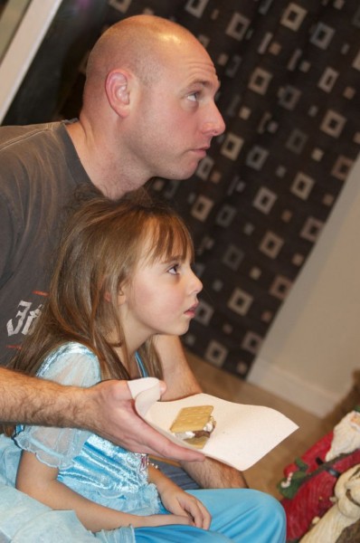 Daddy and Jennifer watching some horrible dancers and easting smores.. One of her favorite treats.  Daddy and Jennifer watching some horrible dancers and easting smores.. One of her favorite treats.